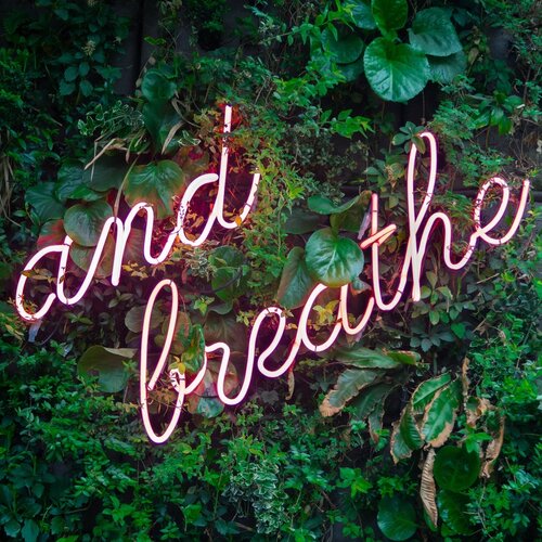 neon sign that says And Breathe